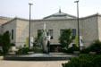 Man with fish statue at an entrance of Shedd Aquarium. Chicago, IL.