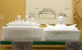Pressed milk glass models of Battleship Oregon & Admiral Dewey on a fort both by Flaccus Brothers Co. of Wheeling, WV related to Spanish American War at Museum of American Glass. Milville, NJ.