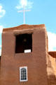 Adobe tower with cross of San Miguel Mission. Santa Fe, NM.
