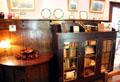 Side table & bookcase with ceramics in dining room at Elbert Hubbard Roycroft Museum. East Aurora, NY.