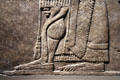Detail of Assyrian relief of winged genie with fancy bracelets from King Ashur-nasir-pal II palace of Nimrud at Brooklyn Museum. Brooklyn, NY.