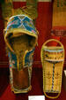 Kiowa cover on Apache cradle board plus toy Apache cradleboard at Oklahoma History Center. Oklahoma City, OK.
