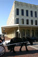 Horse passes Italianate building on The Strand. Galveston, TX.