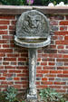 Carved fountain against wall in garden at Oatlands. Leesburg, VA.