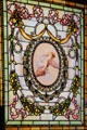 Stained glass window with hand passing torch at Marsh-Billings-Rockefeller Mansion. Woodstock, VT.