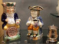 Earthenware Toby Fillpot jugs, one with drinker on barrel & one drinker holding its own small jug at Walker Art Gallery. Liverpool, England.
